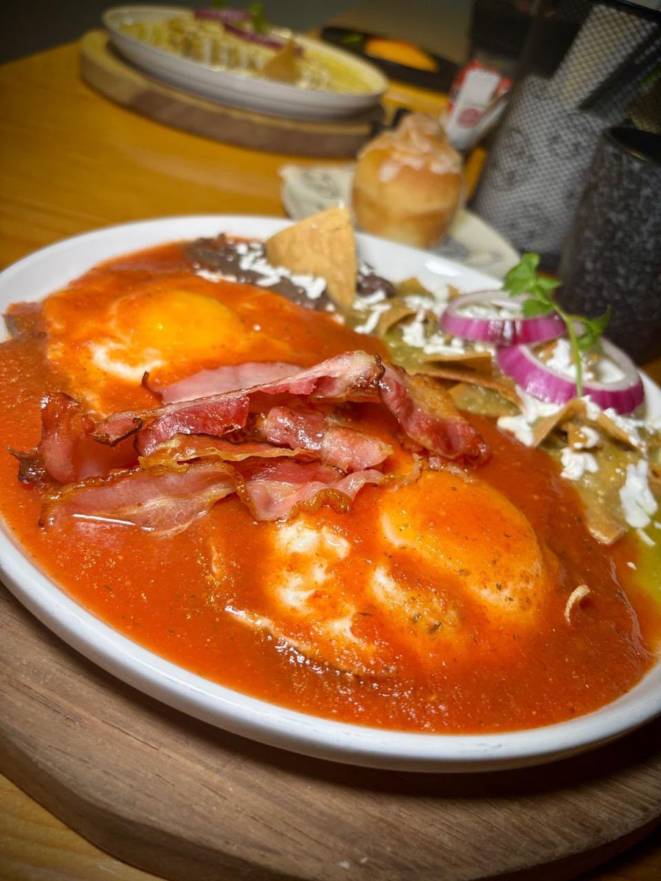 Huevos en salsa roja con tocino y chilaquiles